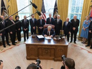 President Trump signs the CARES Act on March 27