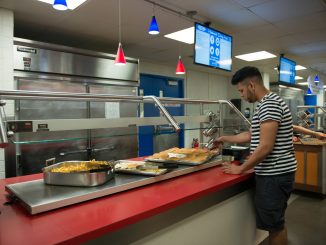 Student selecting foods in the Peregrine Dining Hall on the SUNY New Paltz Campus